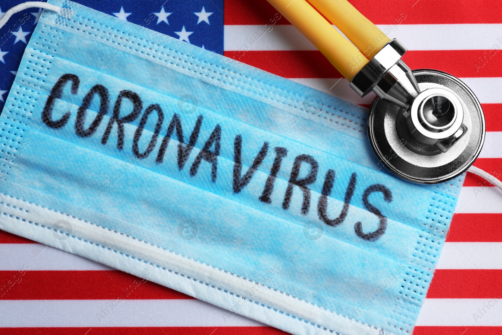 Photo of Medical mask and stethoscope on American flag, flat lay. Coronavirus pandemic in USA