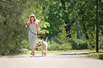 Photo of Young woman and her dog spending time together outdoors. Pet care