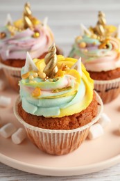 Photo of Cute sweet unicorn cupcakes on plate, closeup