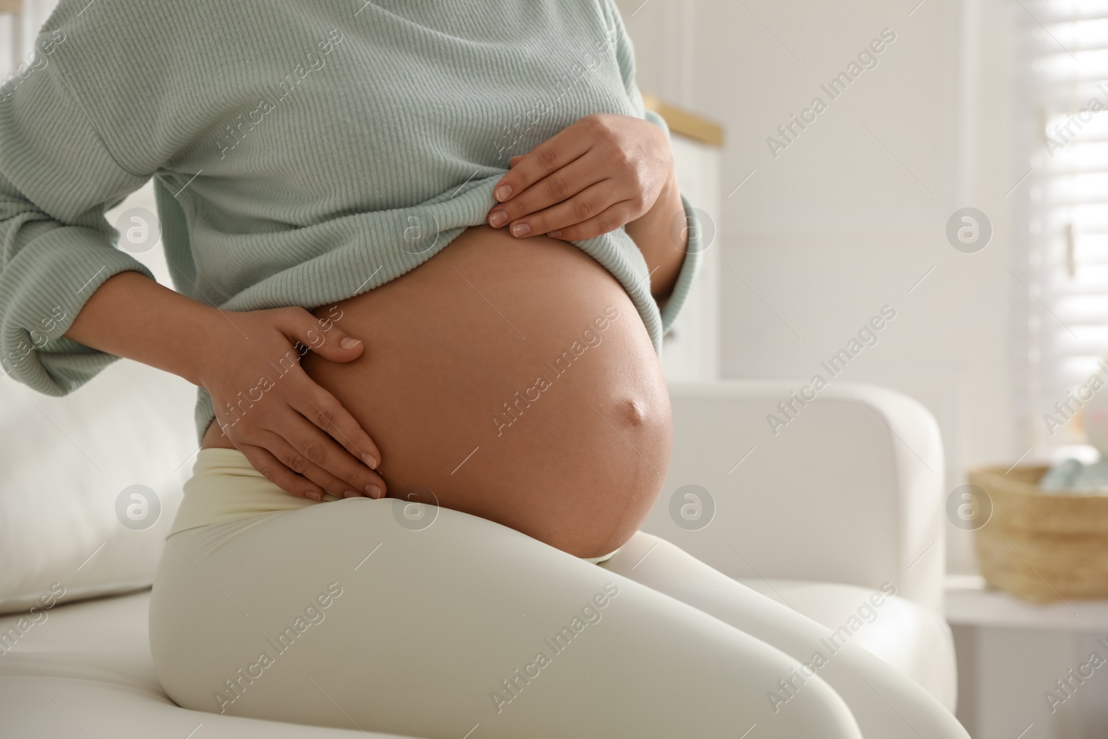 Photo of Pregnant woman at home, closeup. Choosing baby name