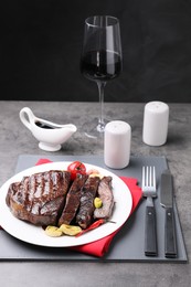 Delicious grilled beef meat served on grey table