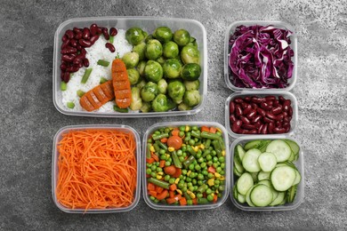 Photo of Set of plastic containers with fresh food on grey   table, flat lay