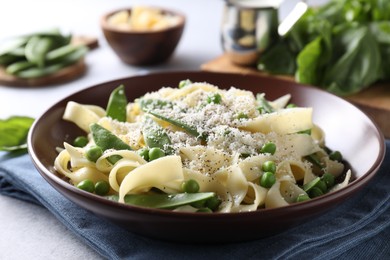 Photo of Delicious pasta with green peas on grey table, closeup