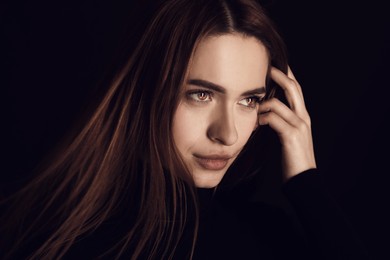 Image of Beautiful woman with captivating eyes on black background, closeup