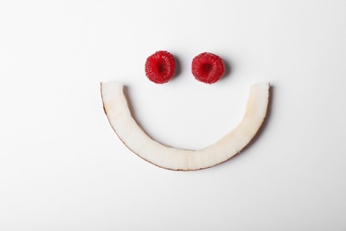 Photo of Funny flat lay composition with coconut and raspberry on white background