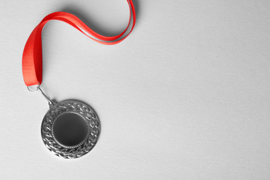 Photo of Silver medal on white background, top view. Space for design