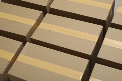 Photo of Many closed cardboard boxes with tape as background