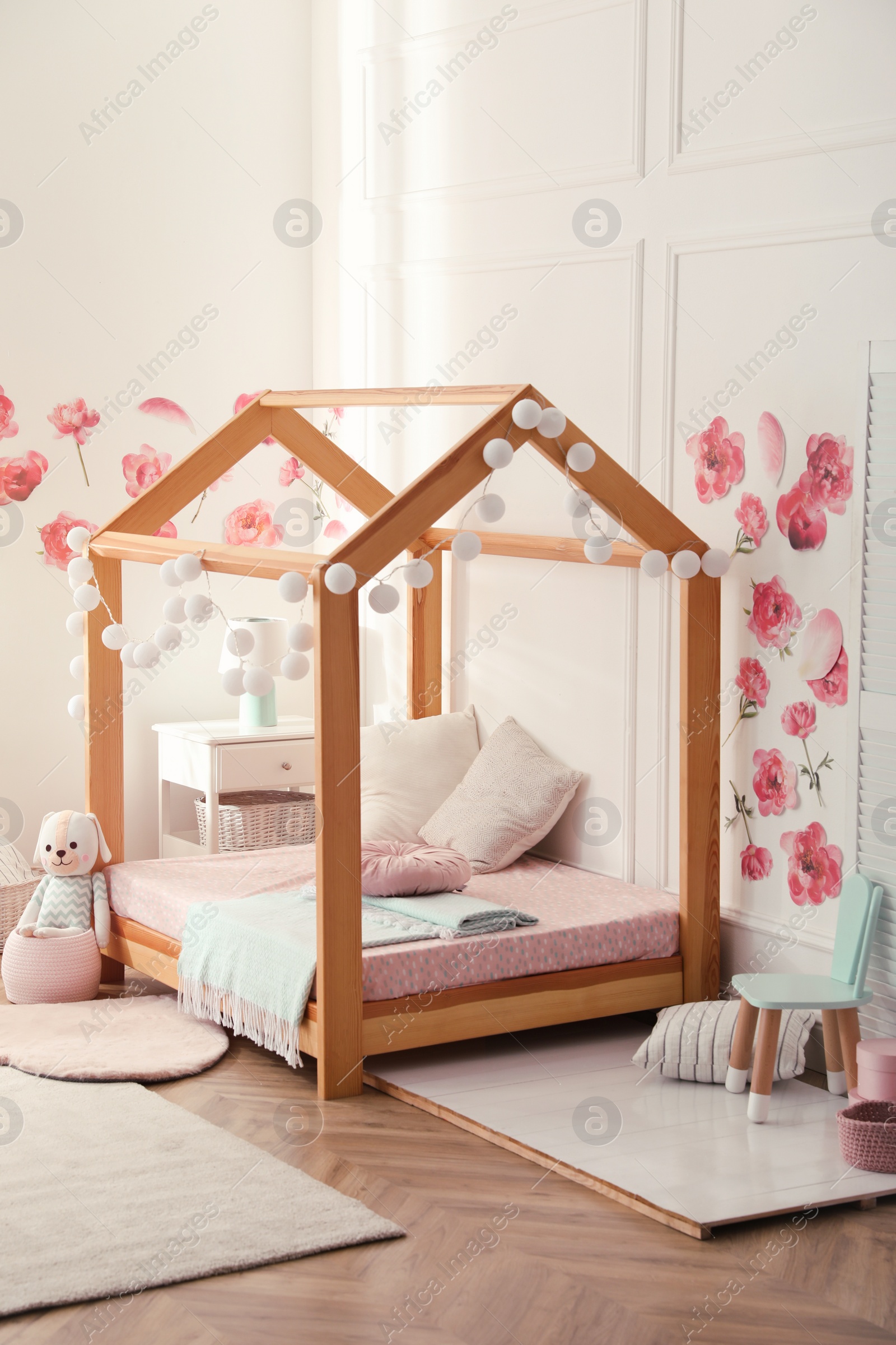 Photo of Stylish child room interior with wooden house bed