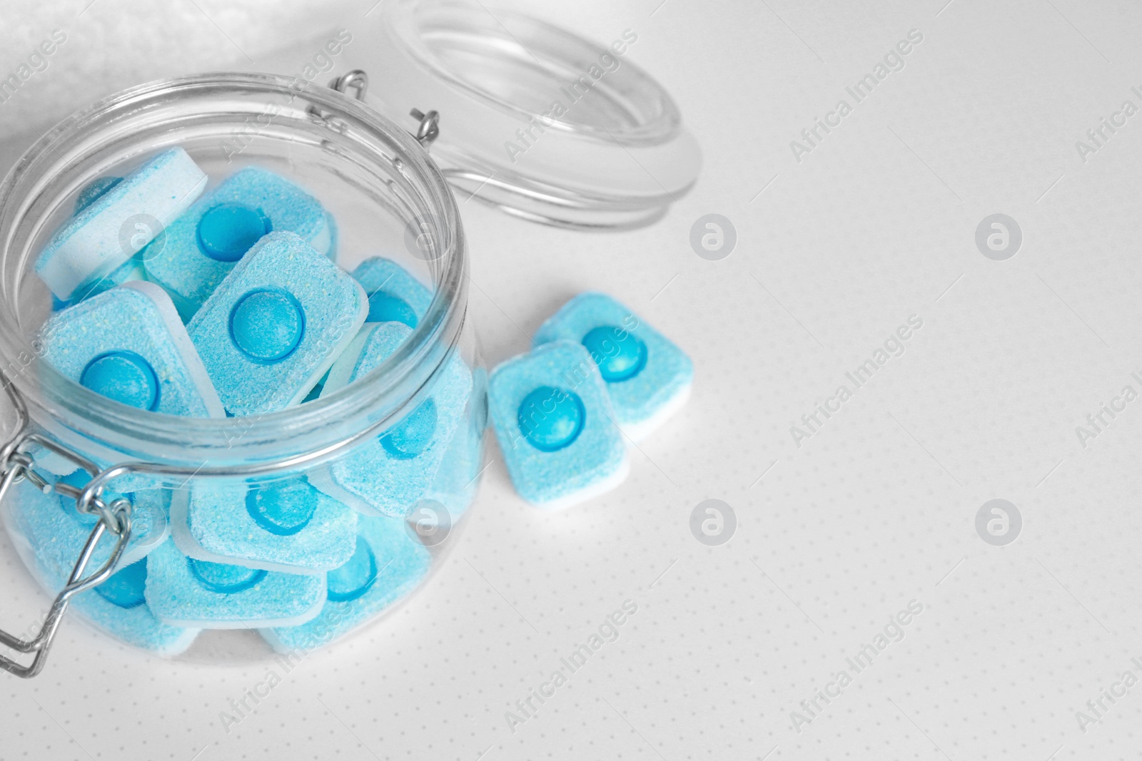 Photo of Jar with water softener tablets on table, closeup. Space for text