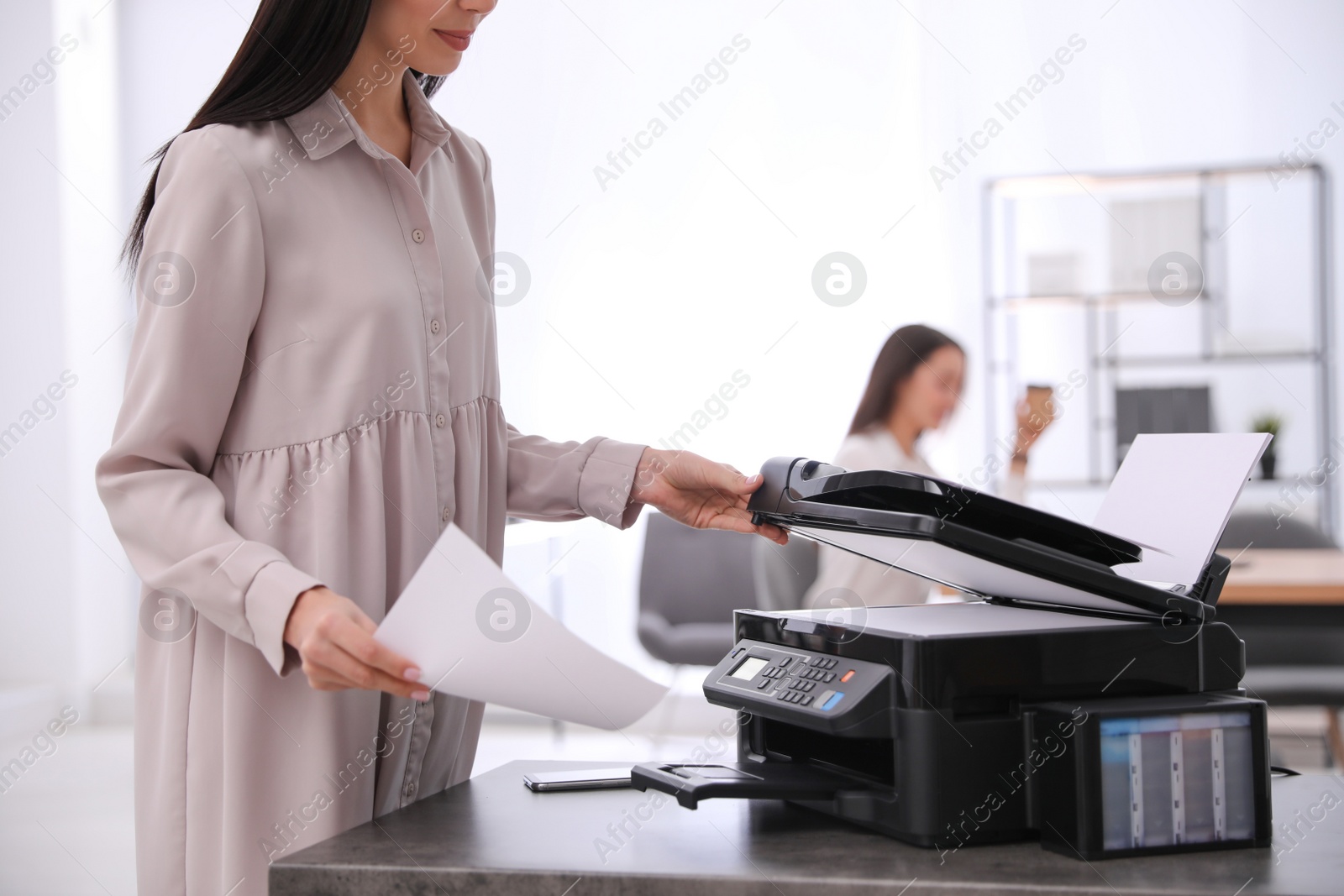 Photo of Employee using modern printer in office, closeup