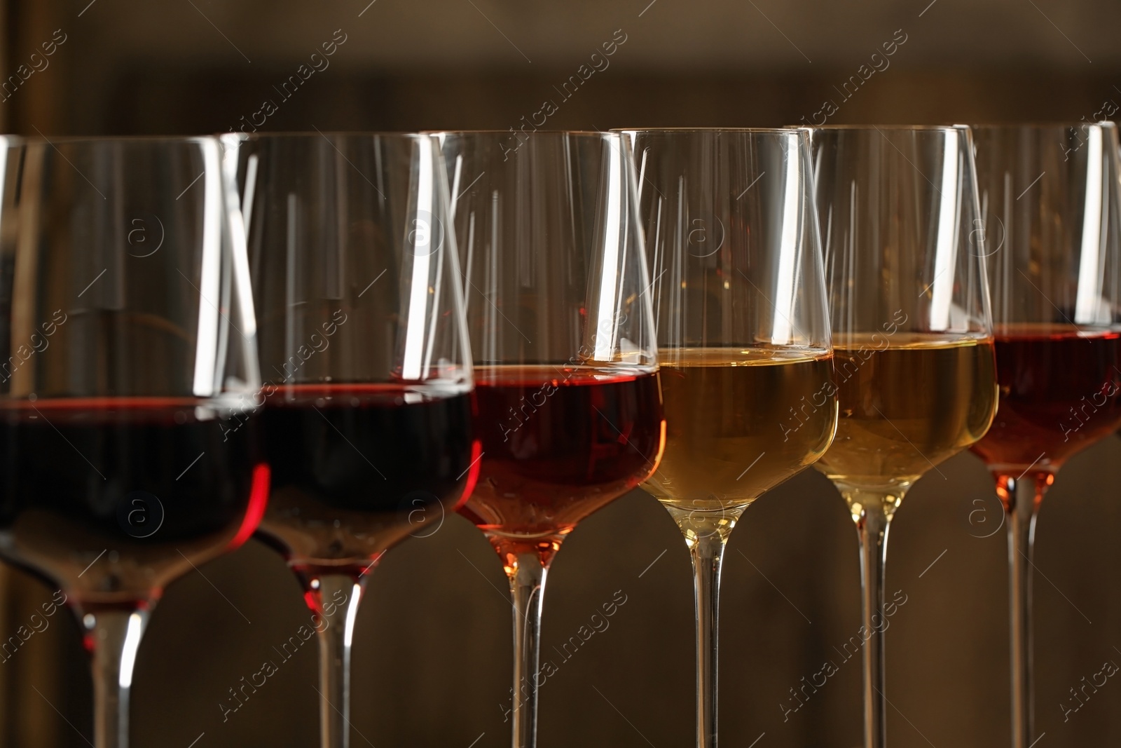 Photo of Glasses of different wines against blurred background, closeup. Expensive collection