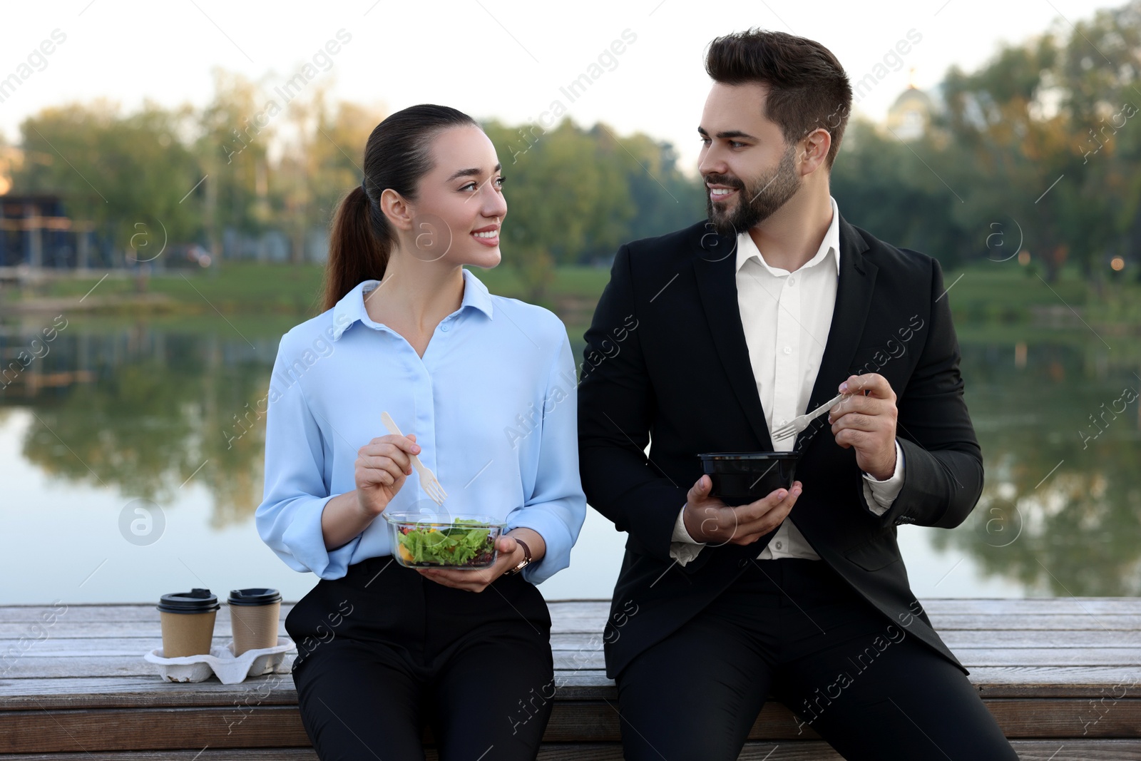 Photo of Smiling business people spending time together during lunch outdoors