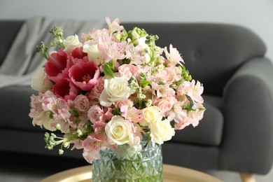 Beautiful bouquet of fresh flowers on coffee table in room