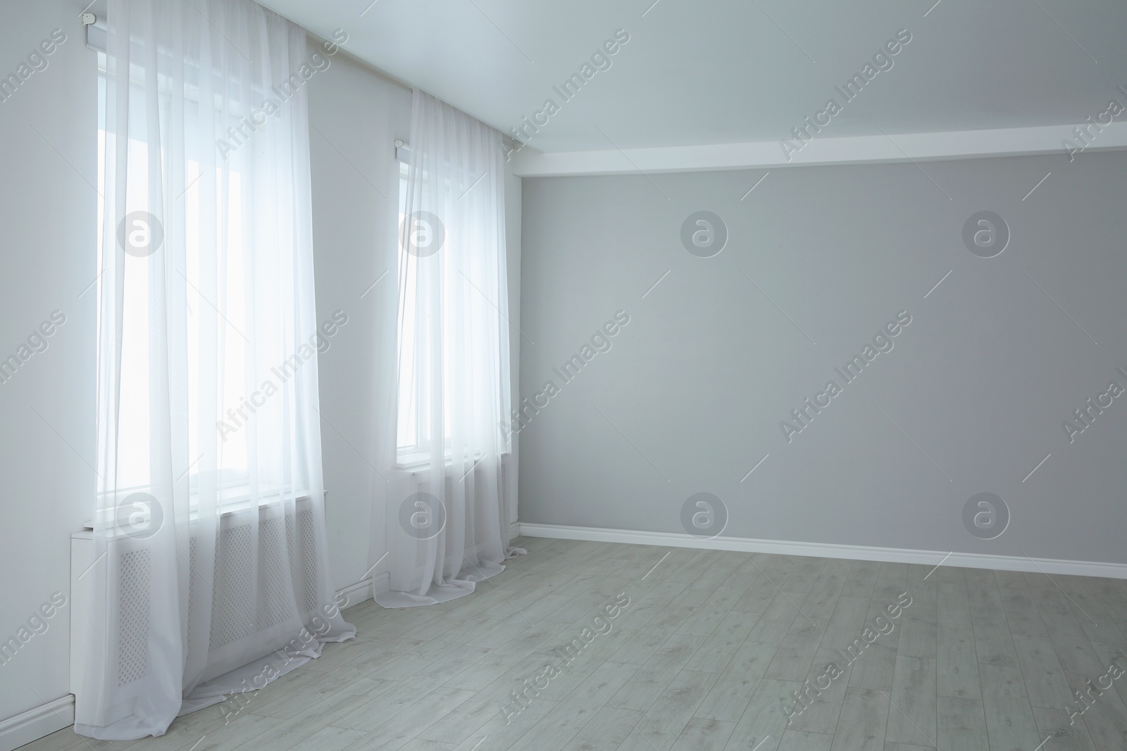 Photo of Empty room with large windows and laminated floor