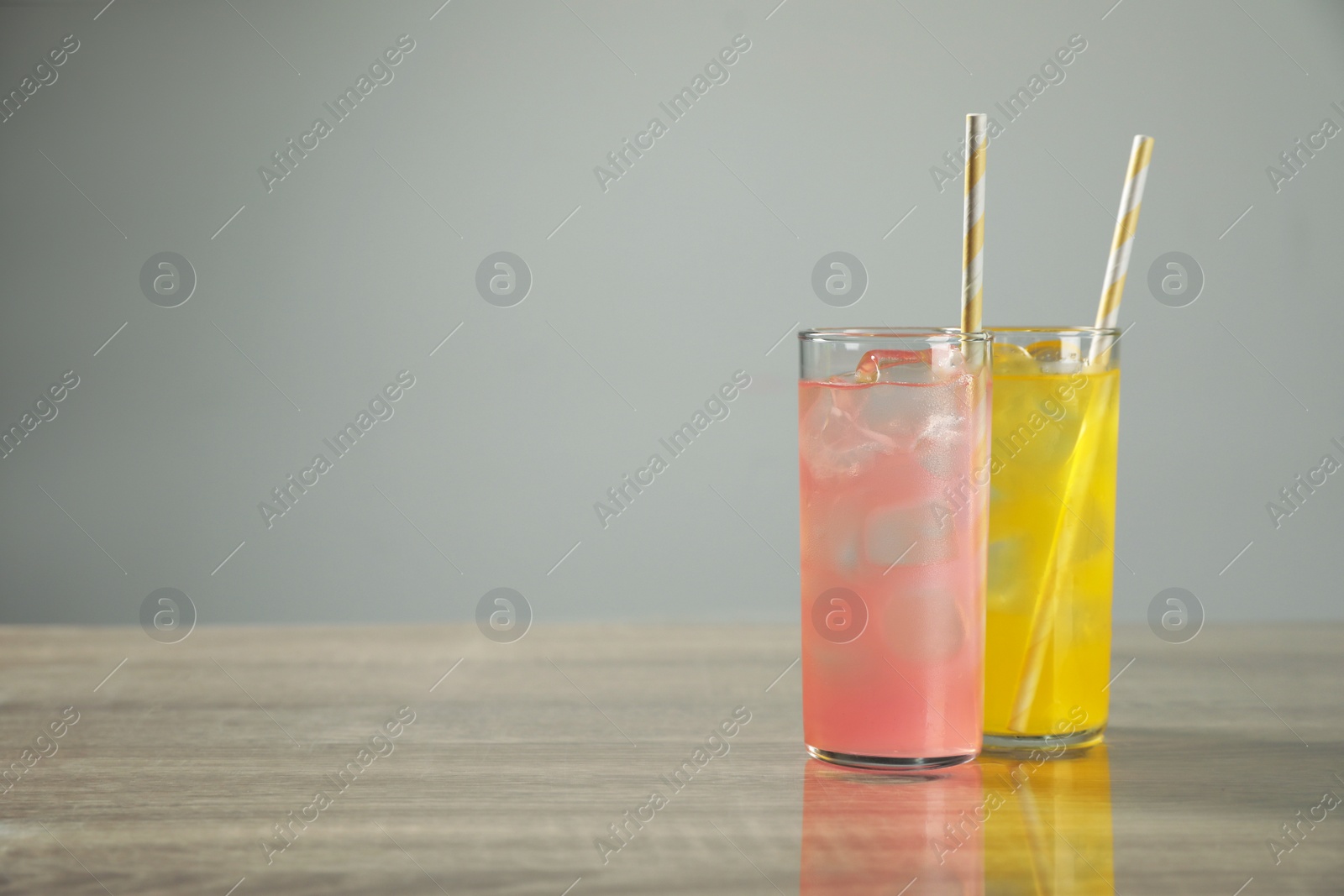 Photo of Delicious refreshing drinks on grey table. Space for text