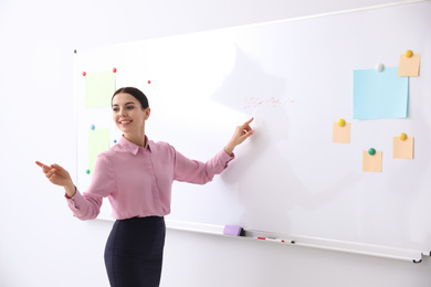 Young teacher near whiteboard in modern classroom