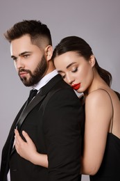 Photo of Handsome bearded man with sexy lady on grey background