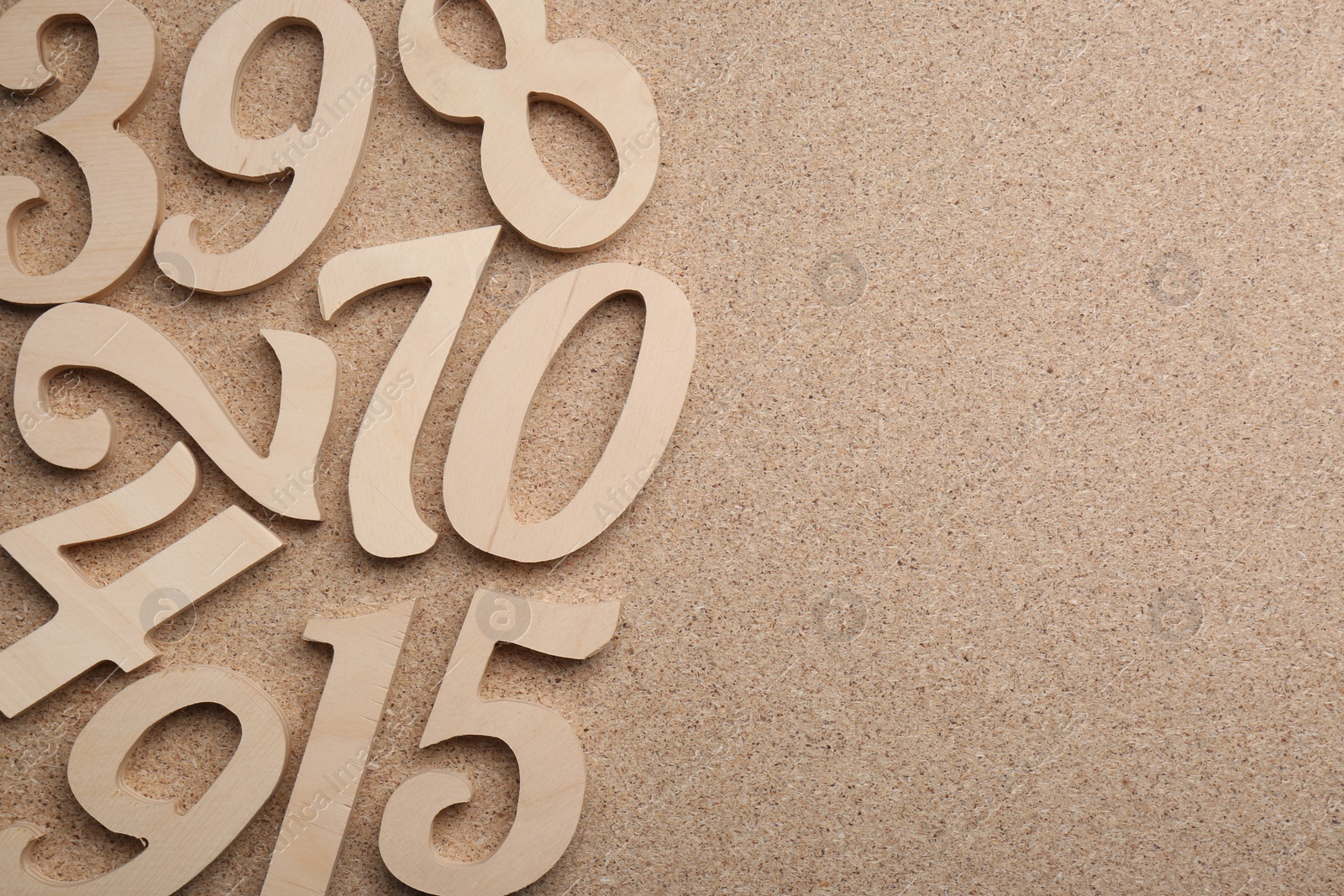Photo of Wooden numbers on fiberboard, flat lay. Space for text