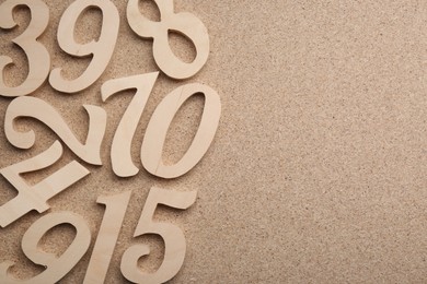 Wooden numbers on fiberboard, flat lay. Space for text