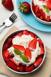 Photo of Delicious strawberries with whipped cream served on white table, flat lay