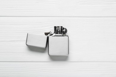 Gray metallic cigarette lighter on white wooden table, top view