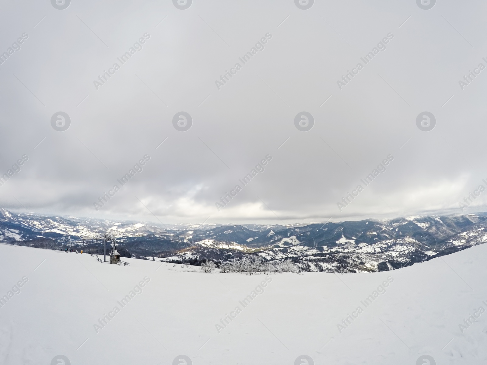 Photo of Picturesque view of snowy hill on cloudy winter day. Ski resort