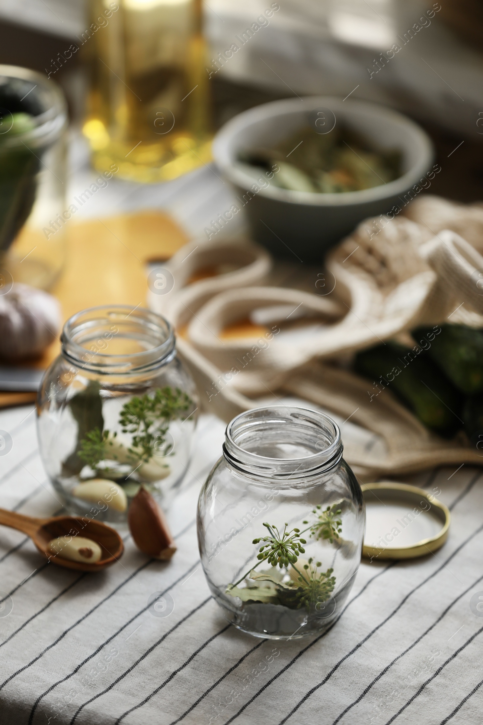 Photo of Empty glass jars and ingredients prepared for canning on table