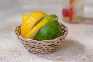 Photo of Basket with fresh citrus fruits on beige table, closeup