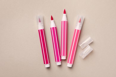 Bright pink markers on light grey background, flat lay