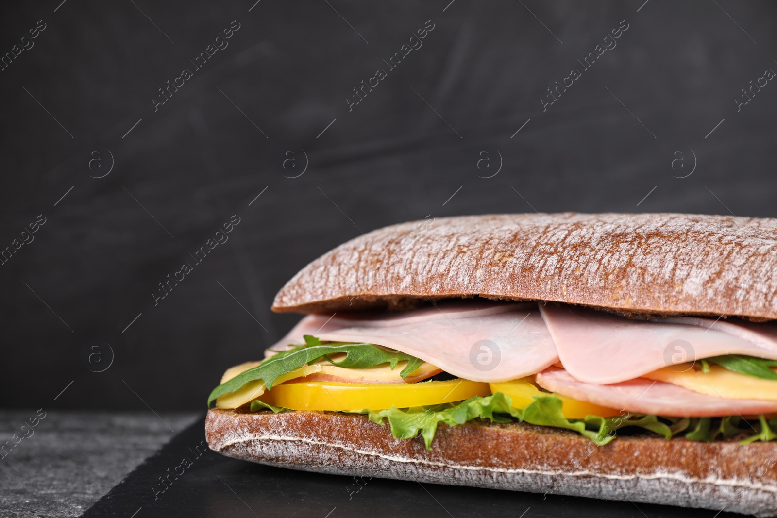 Photo of Tasty sandwich with ham on black table, closeup