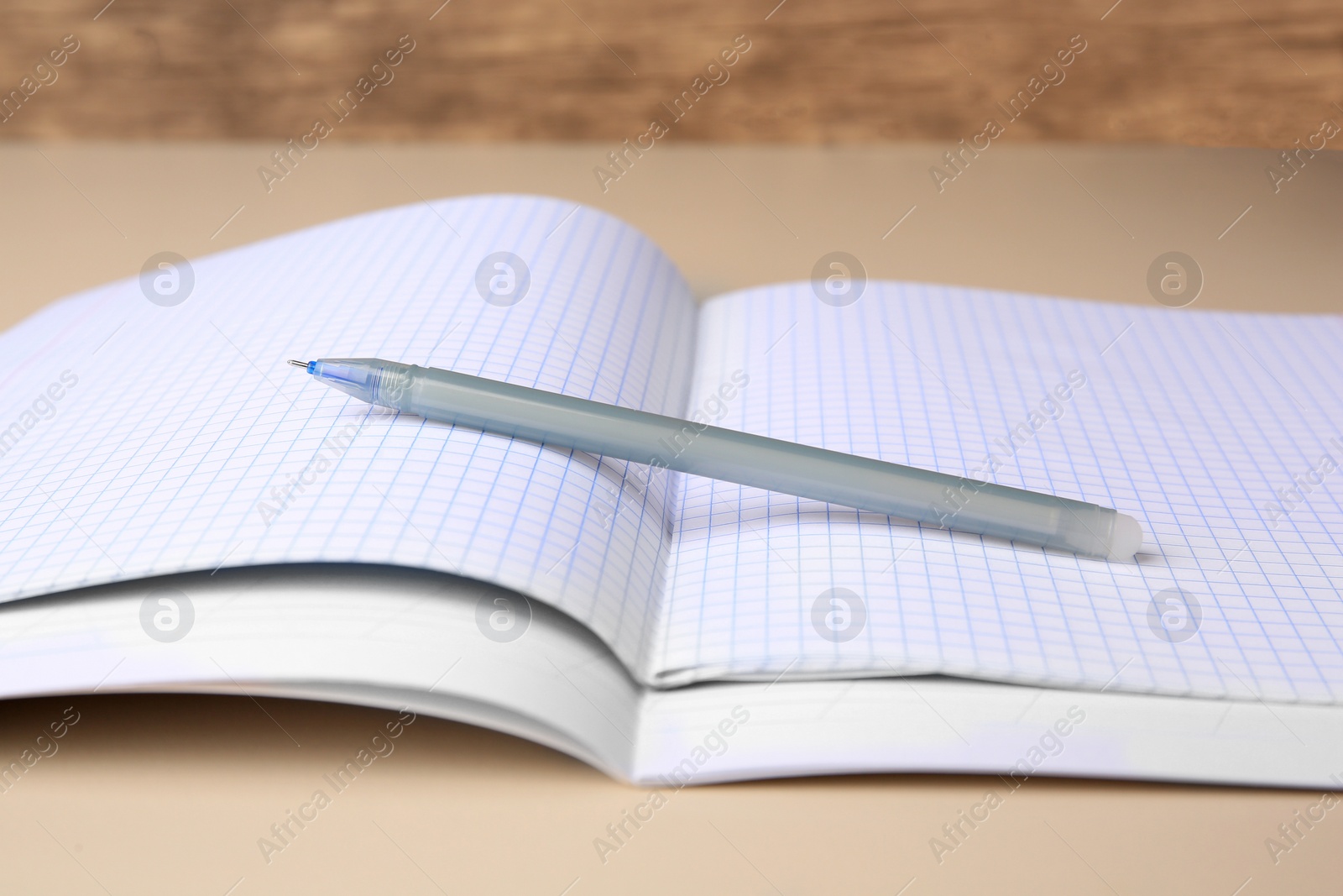 Photo of Copybooks with erasable pen on beige background, closeup
