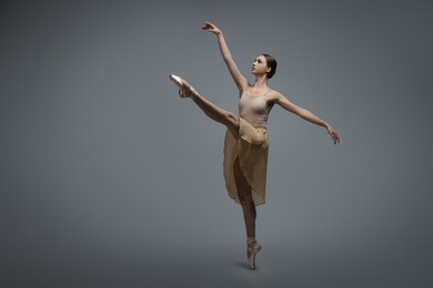 Photo of Young ballerina practicing dance moves on grey background. Space for text