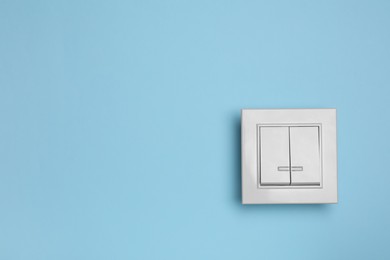 Photo of White light switch on turquoise background. Space for text
