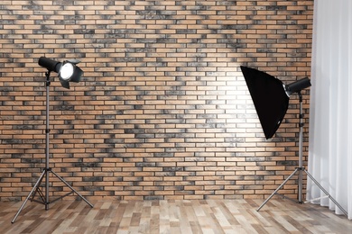 Photo of Professional lighting equipment near wall in photo studio. Space for text