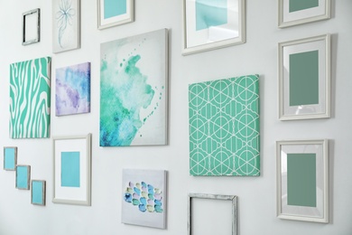 Photo of Many abstract mint paintings on light wall