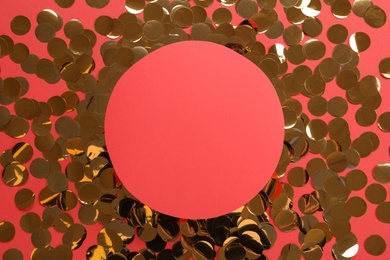 Photo of Frame of shiny golden confetti on red background, flat lay. Space for text