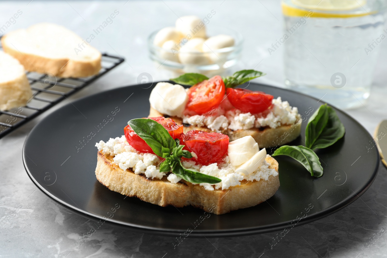 Photo of Tasty fresh tomato bruschettas on grey marble table