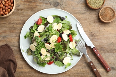 Photo of Delicious carrot salad served on wooden table, flat lay