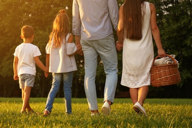 Photo of Happy family with picnic basket in park