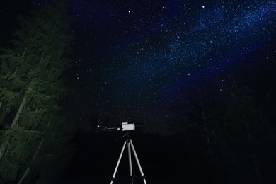 Photo of Modern telescope at night outdoors. Learning astronomy