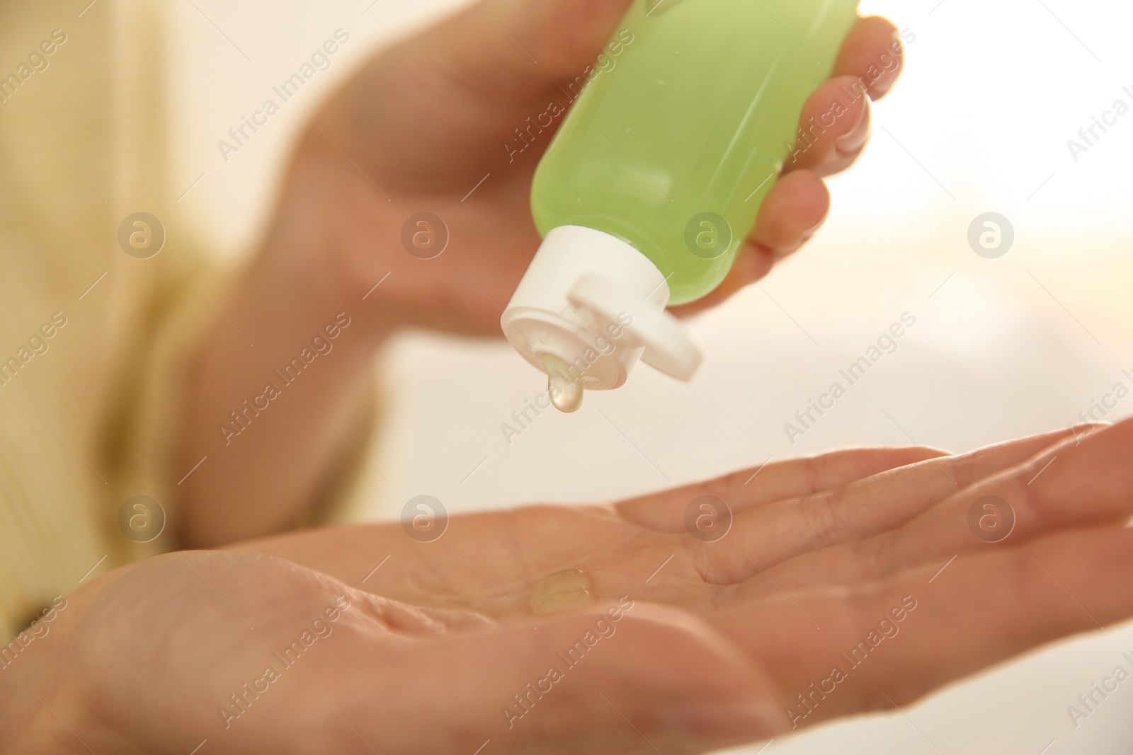 Photo of Woman applying antiseptic gel on blurred background, closeup
