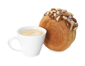Photo of Round croissant with chocolate paste, nuts and cup of coffee isolated on white. Tasty puff pastry