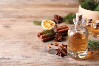 Photo of Anise essential oil and spices on wooden table, space for text