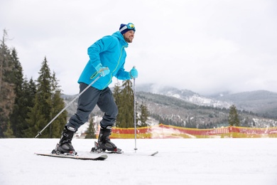 Photo of Male skier on slope at resort, space for text. Winter vacation