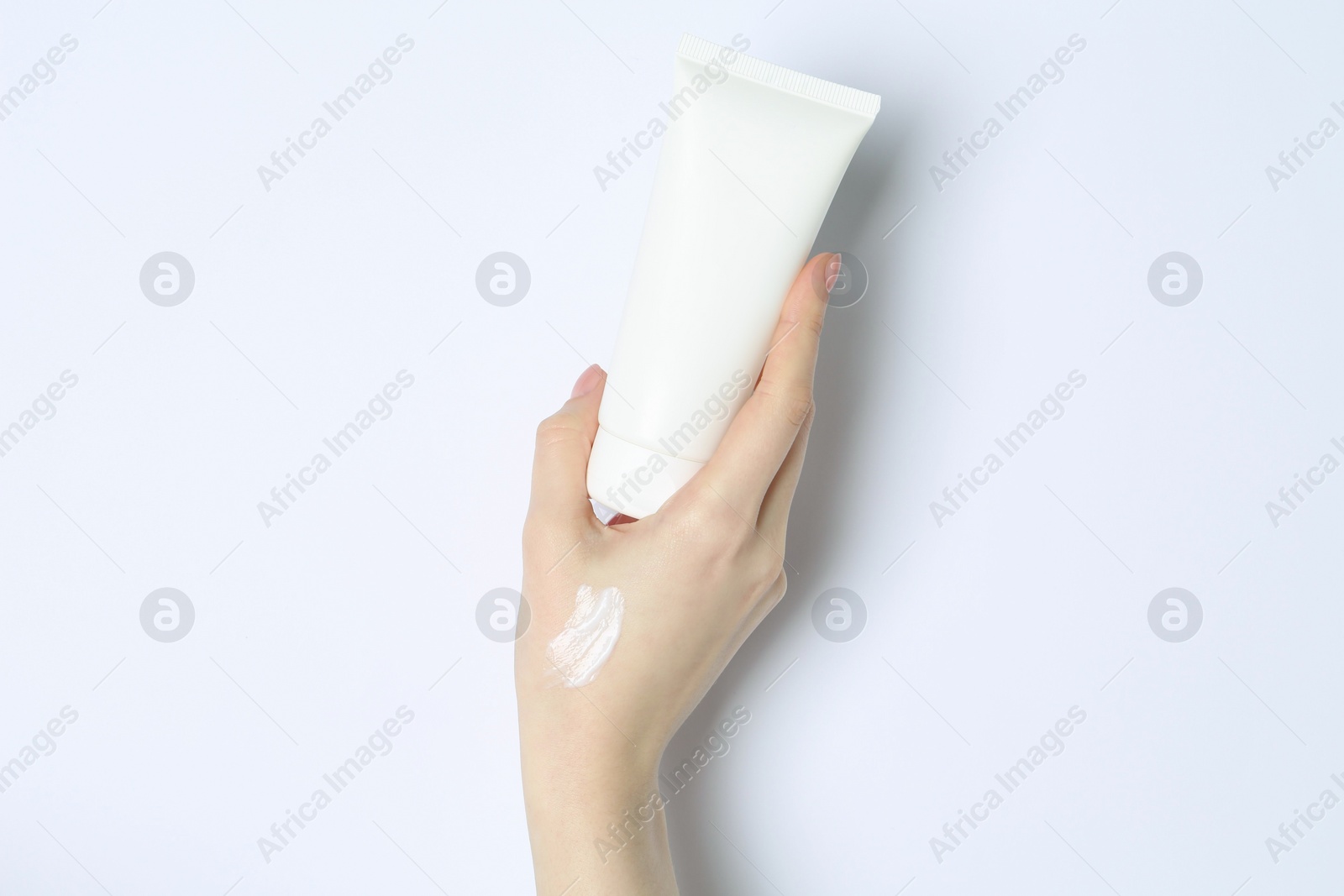 Photo of Woman with tube of cream on white background, closeup