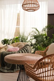 Photo of Indoor terrace interior with wicker furniture and green plants