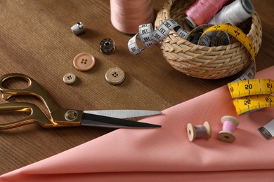 Photo of Set of sewing supplies and accessories on wooden table