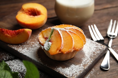 Photo of Delicious peach dessert served on wooden table