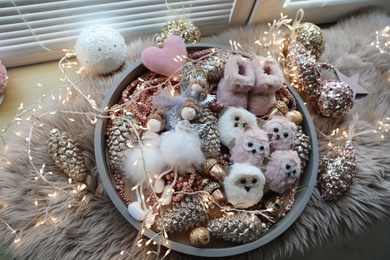Photo of Beautiful Christmas tree baubles, toys and fairy lights on window sill, above view