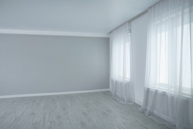 Photo of Empty room with large windows and laminated floor